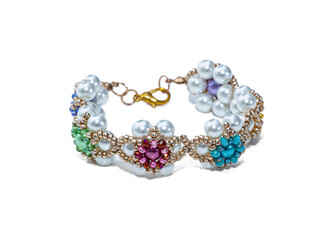 Women's bracelet, woven of gold, blue and pink beads. Isolated on a white background.