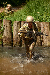 Naklejka premium Special forces soldier with weapon take part in military maneuver. War, army, technology and people concept