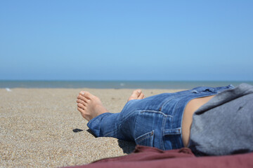 woman lying on the sand sunbathing on the beach
