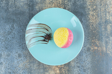 Star anise and cookie in the form of peaches on the plate, on the marble background