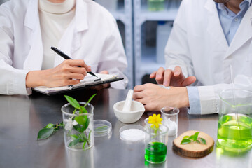 A professional scientists are testing ,recording and discuss the results of eco skin care or...