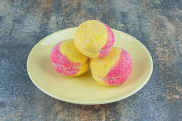 A pile of peach shaped cookies on the plate, on the marble background