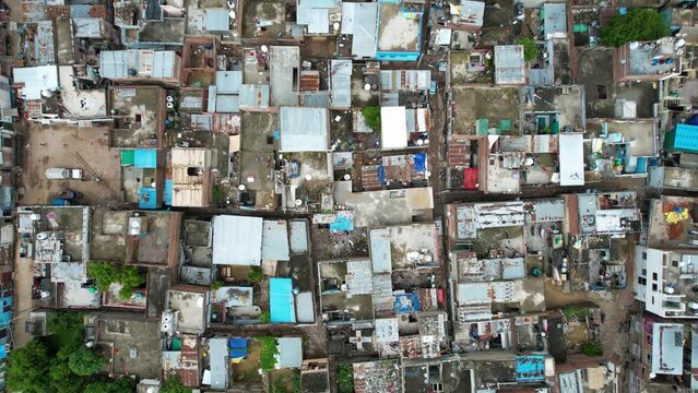 flat down aerial drone shot showing densely packed small homes with brick and concrete with colorful roofs showing rural towns villages near jaipur showing how people live in India asia
