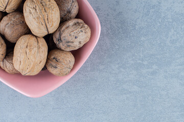 Shelled walnut in the bowl, on the marble background