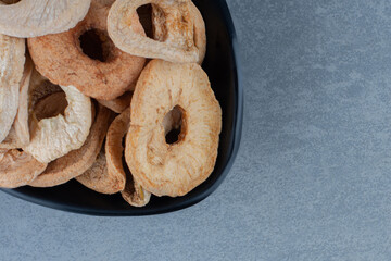 Toothsome dry apple in the bowl, on the marble background