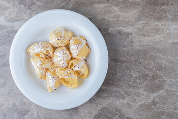 Yogurt on spicy pasta on the plate, on the marble background