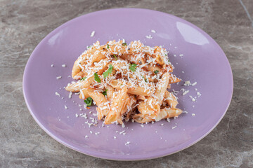 A small portion penne pasta , on the marble background