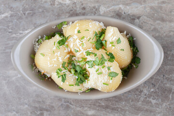 Greens and spicy pasta in bowl , on the marble background