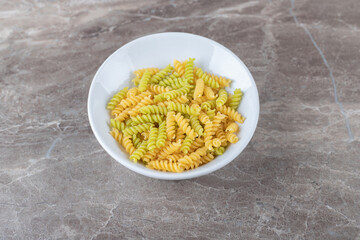 A bowl of mixed pasta , on the marble background