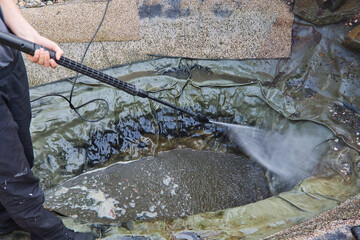 cleaning the pond with a pressure washer