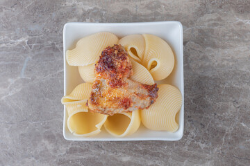 A bowl of pasta with bolognese , on the marble background