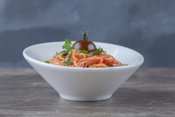 Tasty appetizing classic Italian spaghetti pasta with tomato , on the marble background