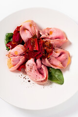 Roast beef ravioli with caramelized peppers and onion and sauce. Modern cuisine