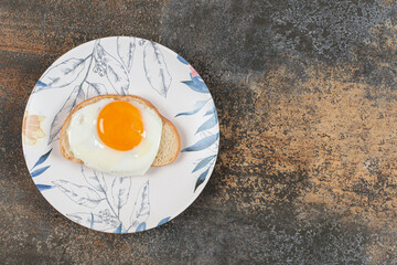 A plate of egg on the white bread slice