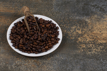 Whole black pepper spices on white plate