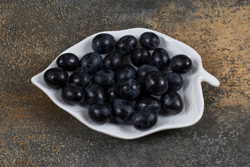 Bunch of black grapes on leaf shaped plate