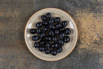 Fresh black grapes on ceramic plate