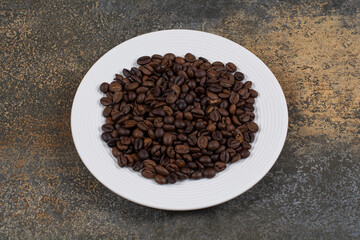 Roasted coffee beans on white plate