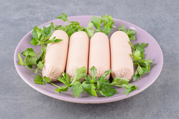 A purple plate of boiled sausages with parsley