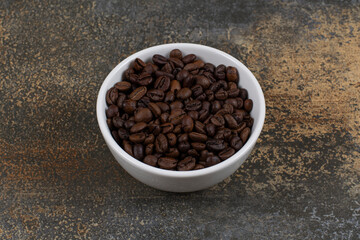 Aromatic coffee beans in white bowl