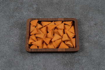 Delicious crunchy chips on wooden plate