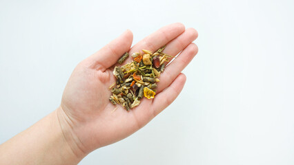 Rodent food from cereals and seeds in hand on a white background