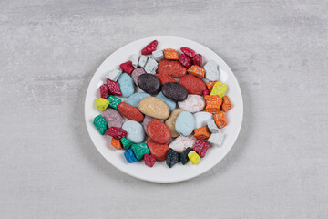 Yummy stone candies on white plate