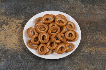 Plate of salted crackers on marble background
