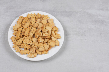 Pile of salted crackers on white plate