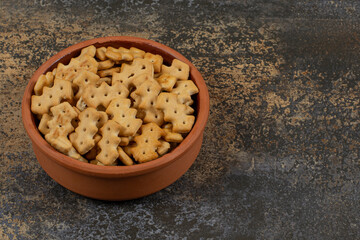 Tasty baked crackers in ceramic bowl