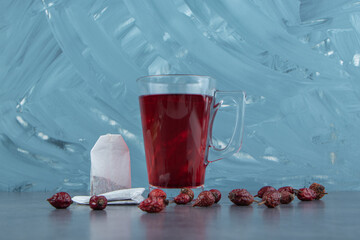 A glass cup of rosehip tea on marble background