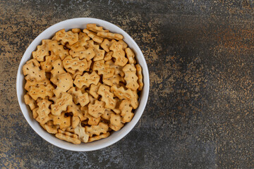 Tasty baked crackers in white bowl