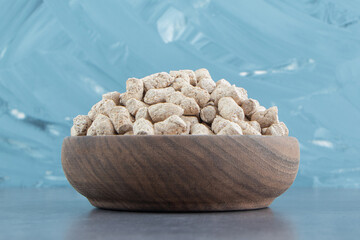 A wooden bowl full of rye crispy cereals