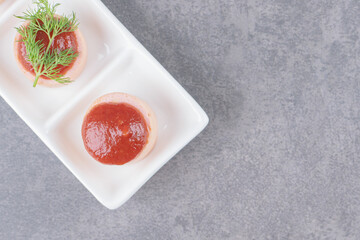 Sliced sausages with ketchup on white plate