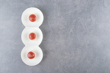 Sliced sausages with ketchup on white plate