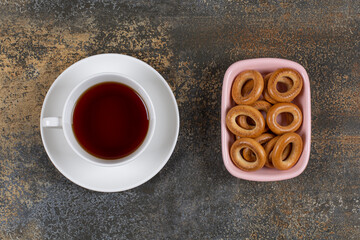 Bowl of crackers and cup of tea on marble background