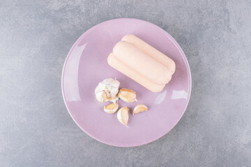A purple plate of boiled sausages with garlics