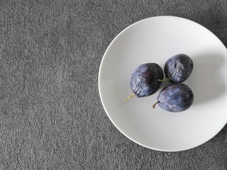 白い皿の上の完熟プルーン３個（シュガープルーン）