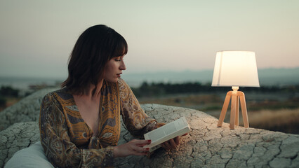 Girl read book at night on the mountain with abat jour lamp