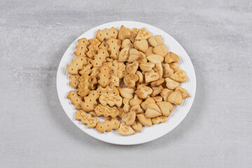 Pile of salted crackers on white plate