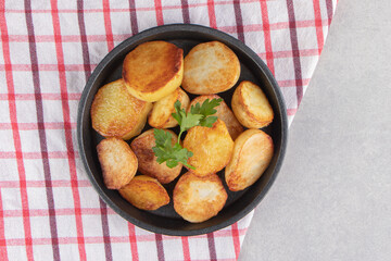 Slices of fried potatoes on black plate