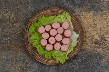 Fried sliced sausages on wooden board
