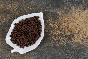 Roasted coffee beans on leaf shaped plate