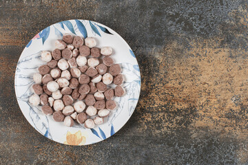 Yummy brown candies on colorful plate