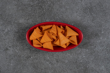 Delicious crunchy chips in red bowl