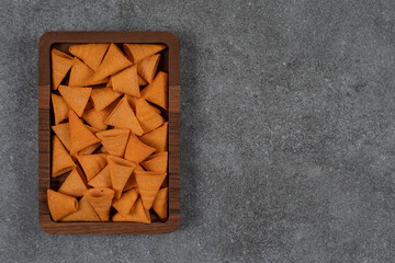 Delicious crunchy chips on wooden plate