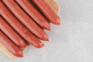 Bunch of smoked sausages on wooden board
