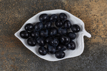Bunch of black grapes on leaf shaped plate