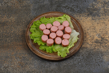 Fried sliced sausages on wooden board