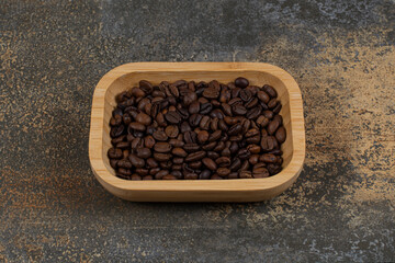 Roasted coffee beans on wooden plate